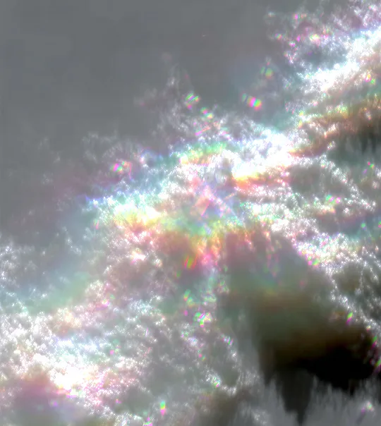 Close-up of iridescent water ripples reflecting colorful light.